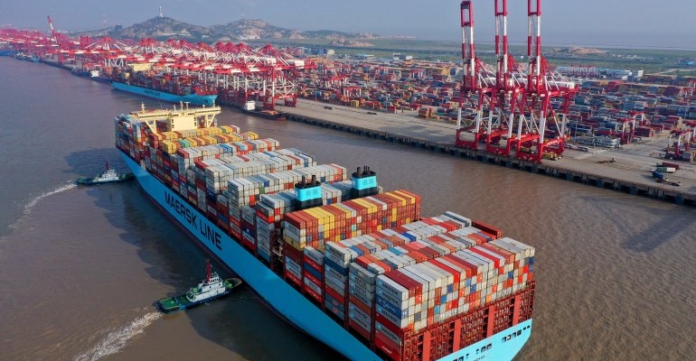 Tugboats guide a container ship at the Yangshan Deepwater Port in Shanghai, China.